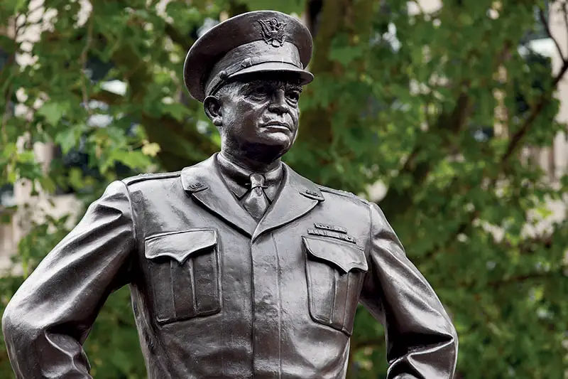 Statue of Dwight Eisenhower with green leaves in the background